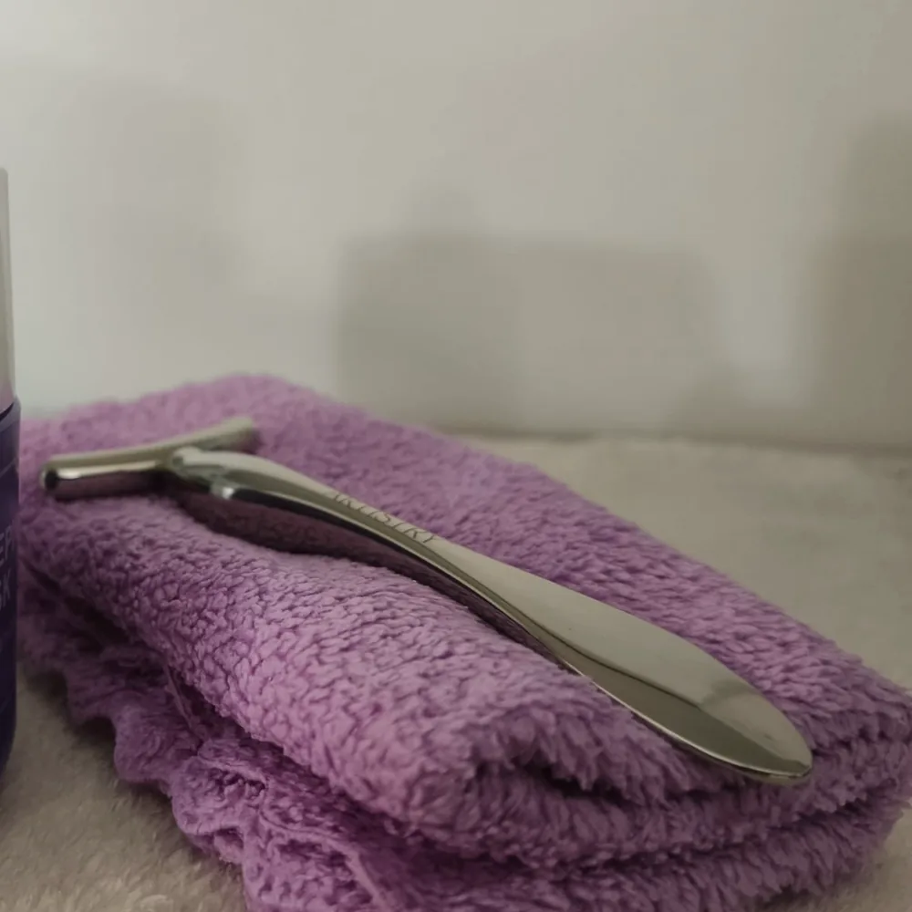 Prosop pufos mov și o spatulă de inox, pregătite pentru un tratament facial.